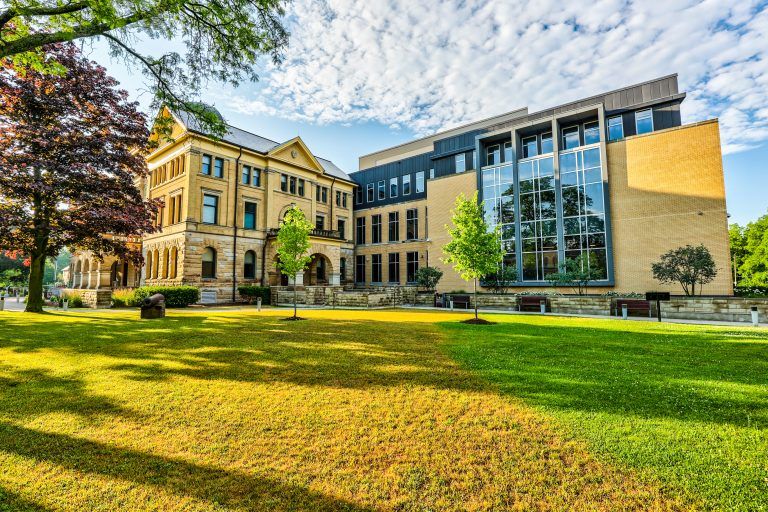 The Elgin County Courthouse and its modern glass addition across a sunlit lawn.